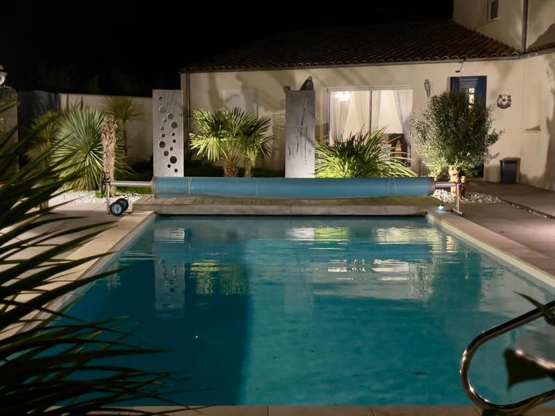 La piscine extérieure découverte de nuit.