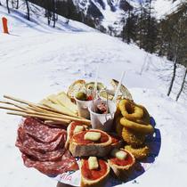 Plateau de charcuteries et apéritifs avec pistes de ski en arrière-plan