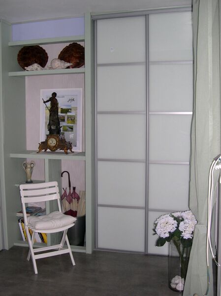 Entrée rez de chaussée avec placard, chaise blanche et décorations.