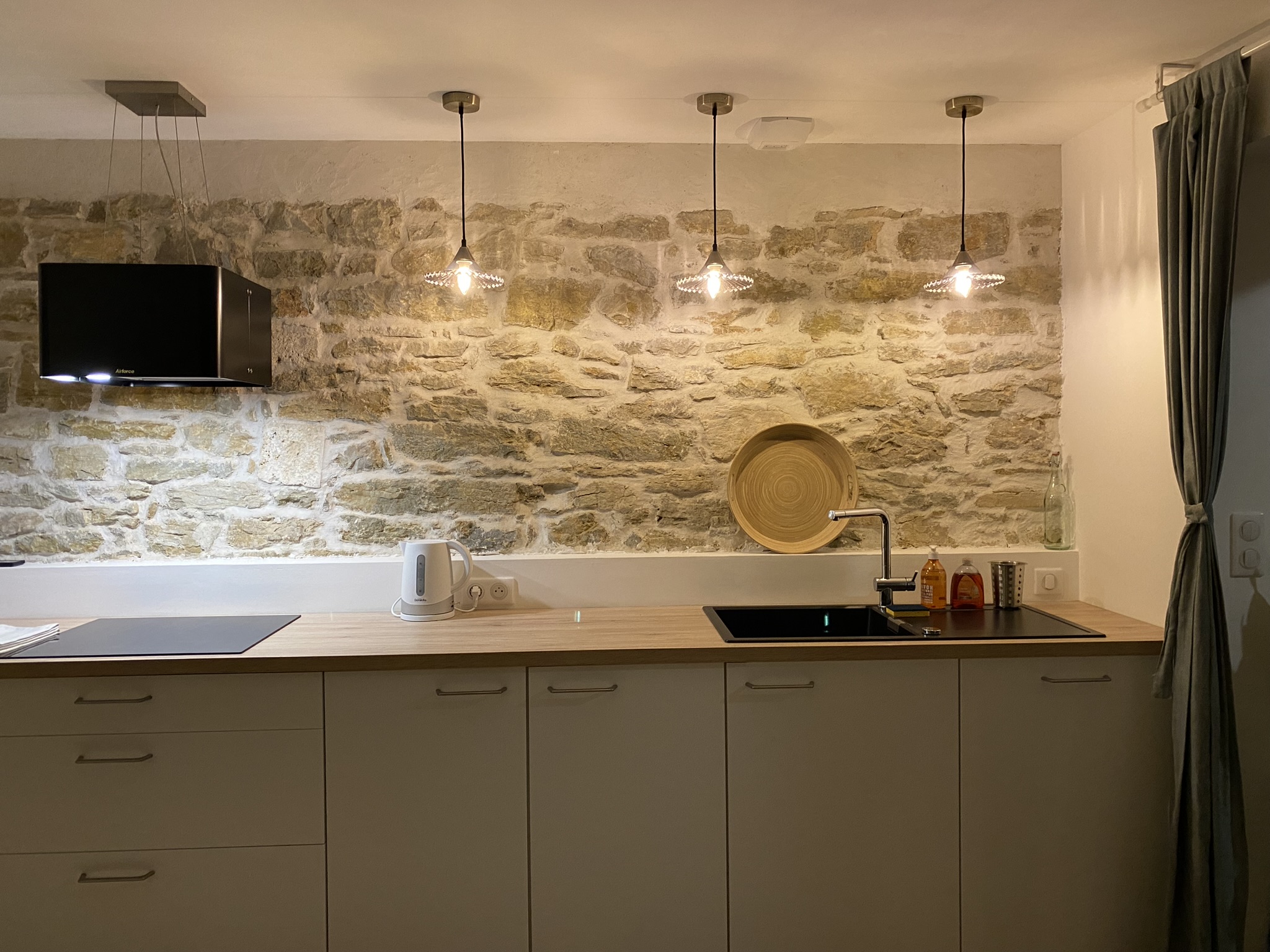 Cuisine avec mur en pierres apparentes au Gîte des Nines à La Chapelle en Vercors