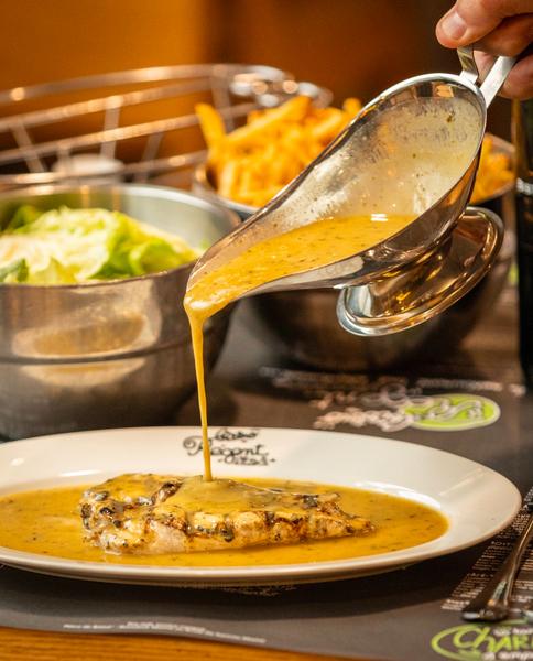 Une sauce versée sur de la poitrine de poulet.