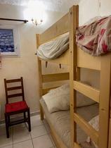 Vue de chambre à coucher avec lits superposés, ameublement bois, fenêtre