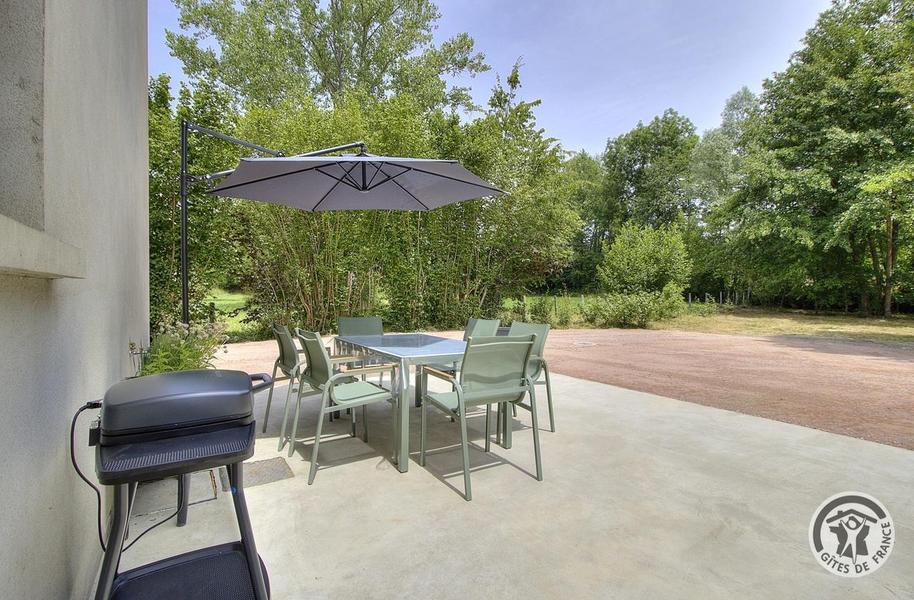 Gîte du Moulin à Thizy les Bourgs en Haut Beaujolais et à 10 km du Lac des Sapins - Rhône : la terrasse privative avec salon de jardin, barbecue et chaises longues.