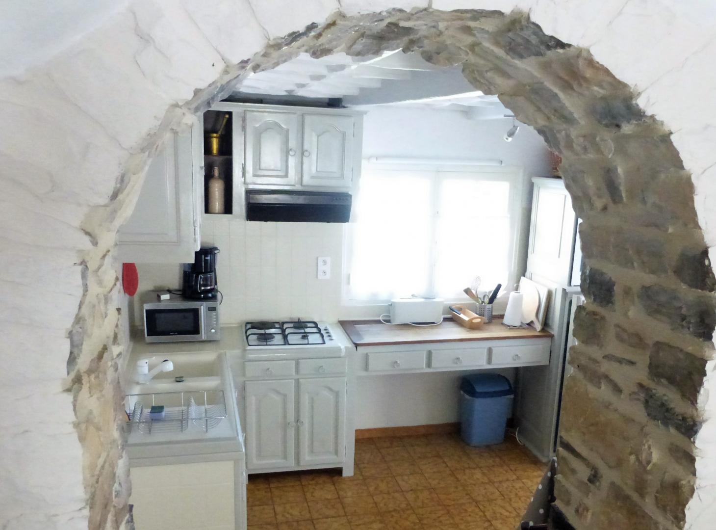 Accès à la cuisine très claire depuis la salle de séjour.
