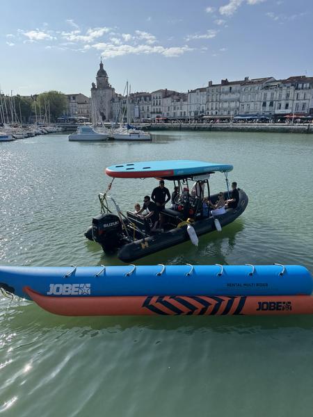 Le zodiac dans le port de la Rochelle, une bouée tractée banane sur le côté, un paddle géant sur le toit.