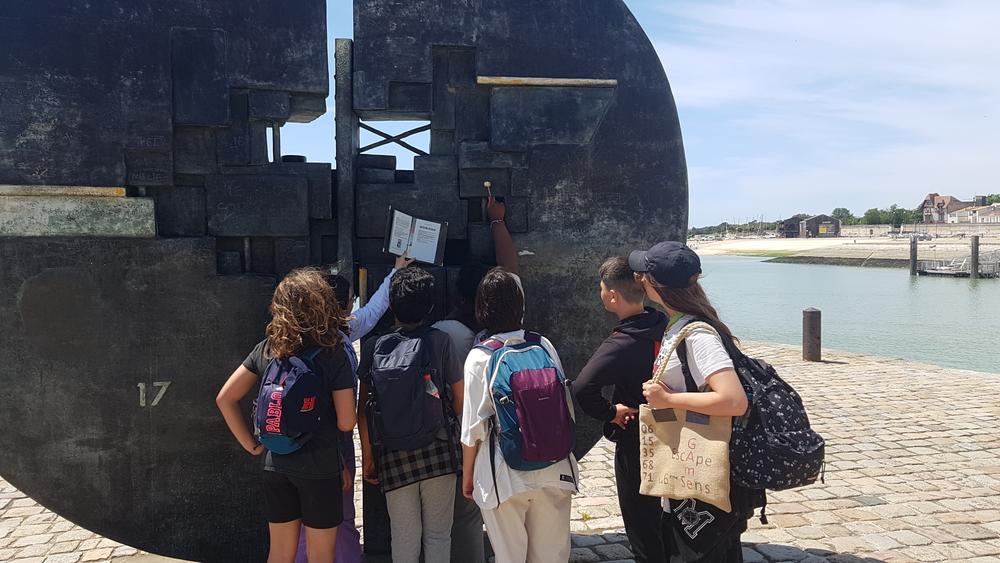 Un groupe de collégiens devant une oeuvre d'art.