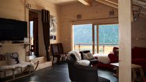 Salon avec canapé, télévision, grande baie vitrée donnant accès au balcon