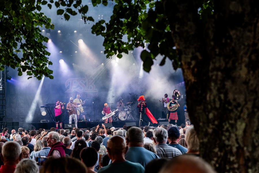 Scène du Surgères Brass Festival la nuit avec des projecteurs, des fumigènes et du public