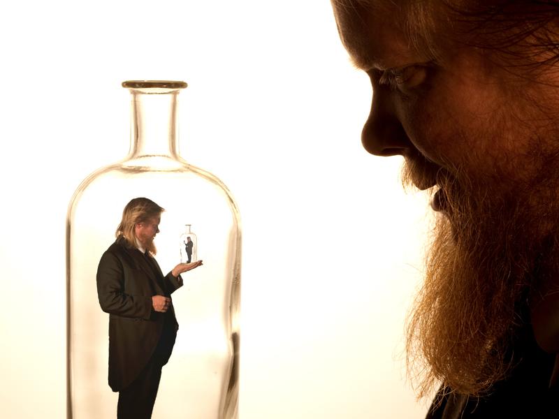 Un homme tient dans sa main une bouteille contenant un homme qui tient dans sa main une bouteille...etc