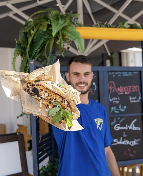Un employé présente une pizza