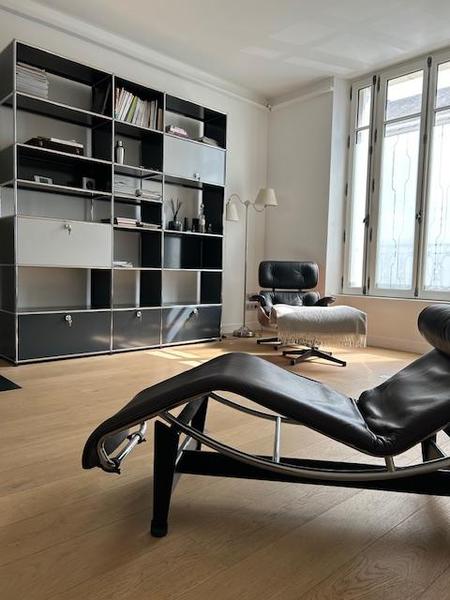 Salon avec fauteuil et bibliothèque.