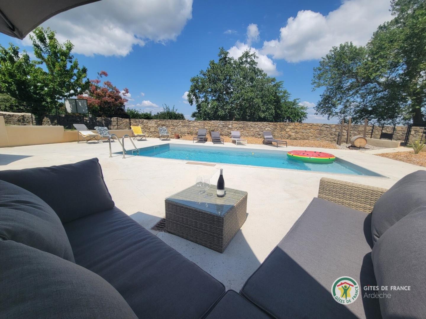 Détente au bord de la piscine partagée de la propriété