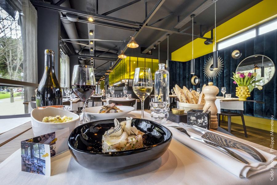 Un table dressée et servie de plats et de verres de vin