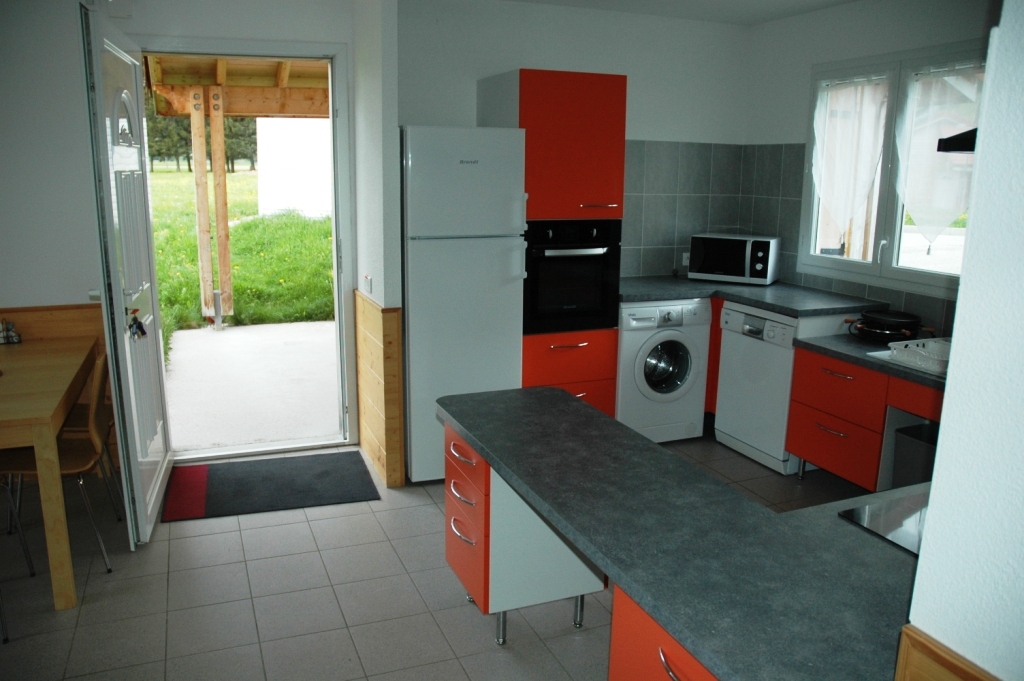 Espace de vie 2 avec l'entrée et la cuisine ouverte bien équipée aux Chalets de la Frache à Vassieux en Vercors