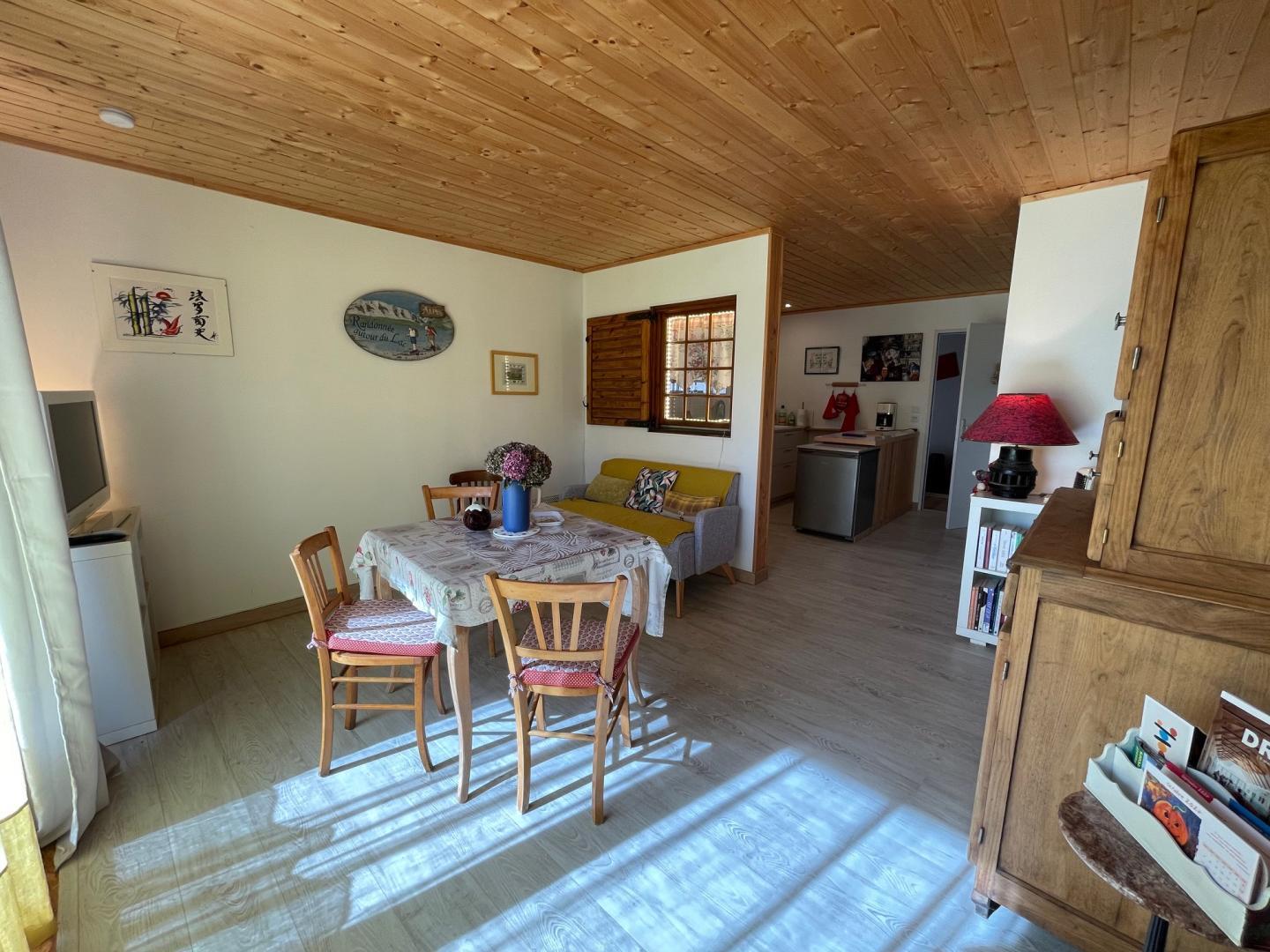 Le séjour/salon et la cuisine au fond