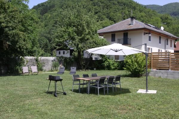 Jardin avec barbecue et chaises longues