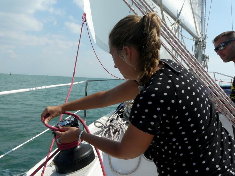 une dame enroulant une corde sur un bateau.