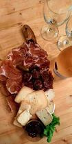 Planche à découper en forme d'île de Corse avec charcuterie, fromage, olive et basilic