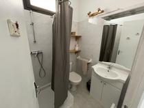 Salle de bains carrelée lumineuSalle de bains carrelée lumineuse avec bac à douche, fenêtrese avec bac à douche