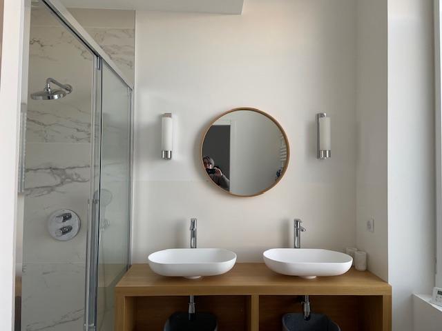 Salle d'eau avec douche et double vasque.