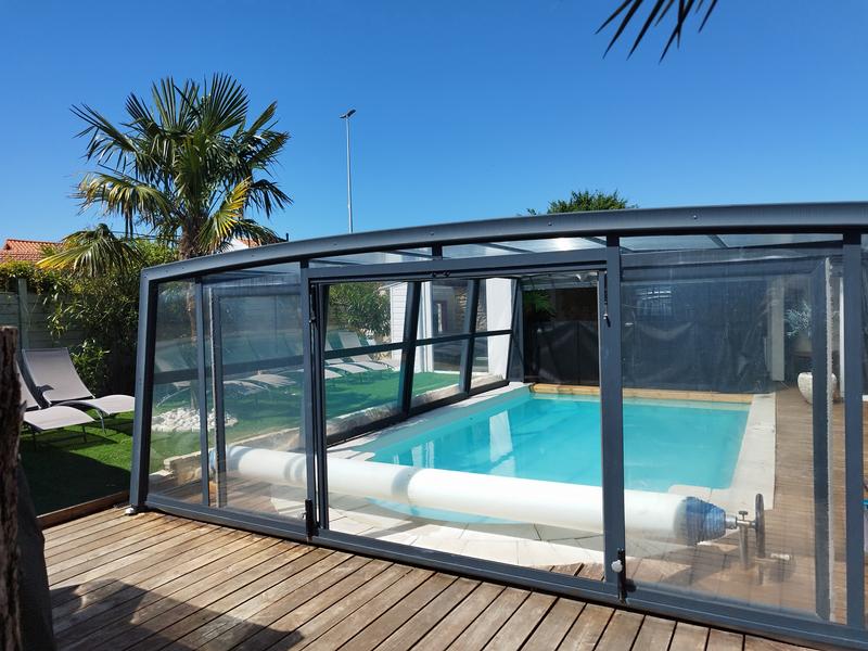 La piscine extérieure couverte par un dôme, des transats.