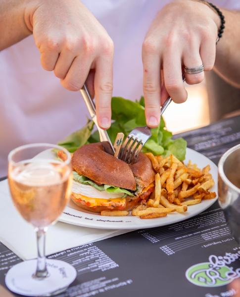 Une personne découpant son burger.