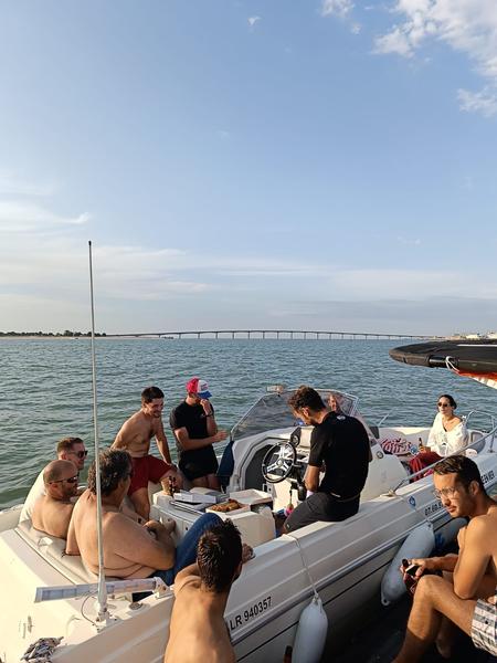 Des personnes sur deux bateaux à l'arrêt, en train de prendre l'apéro.