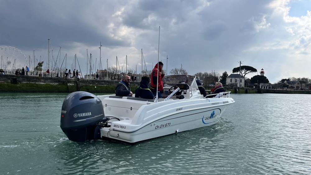 Un bateau à moteur avec des passagers dans le port.