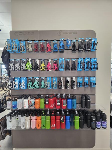 un étalage de bidon et de porte-bidon de toutes les couleurs dans le magasin.
