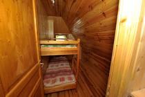 Coin chambre d'enfants sous combles avec lits superposés, ameublement bois, fenêtre