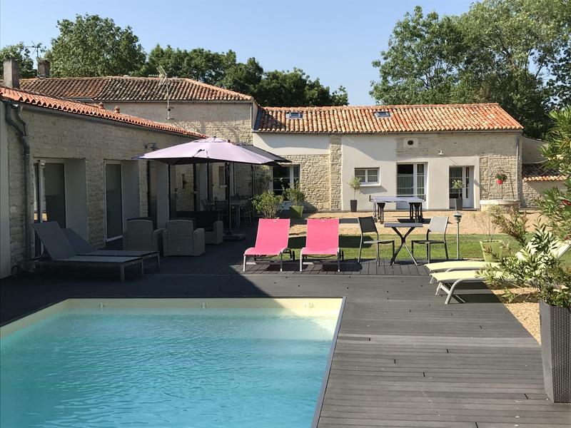 Piscine extérieure derrière la maison avec transats