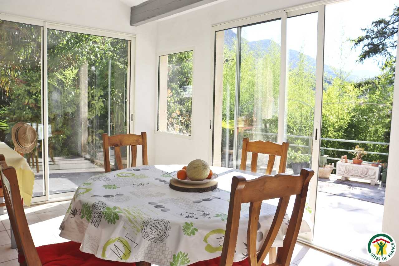 Espace repas sous la véranda, donnant directement sur la terrasse