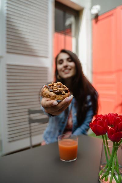 Une dame présentant un cookie garnie à l'appareil photo.