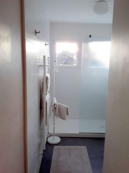 Une salle d'eau avec cabine de douche ouverte et sèche serviette.