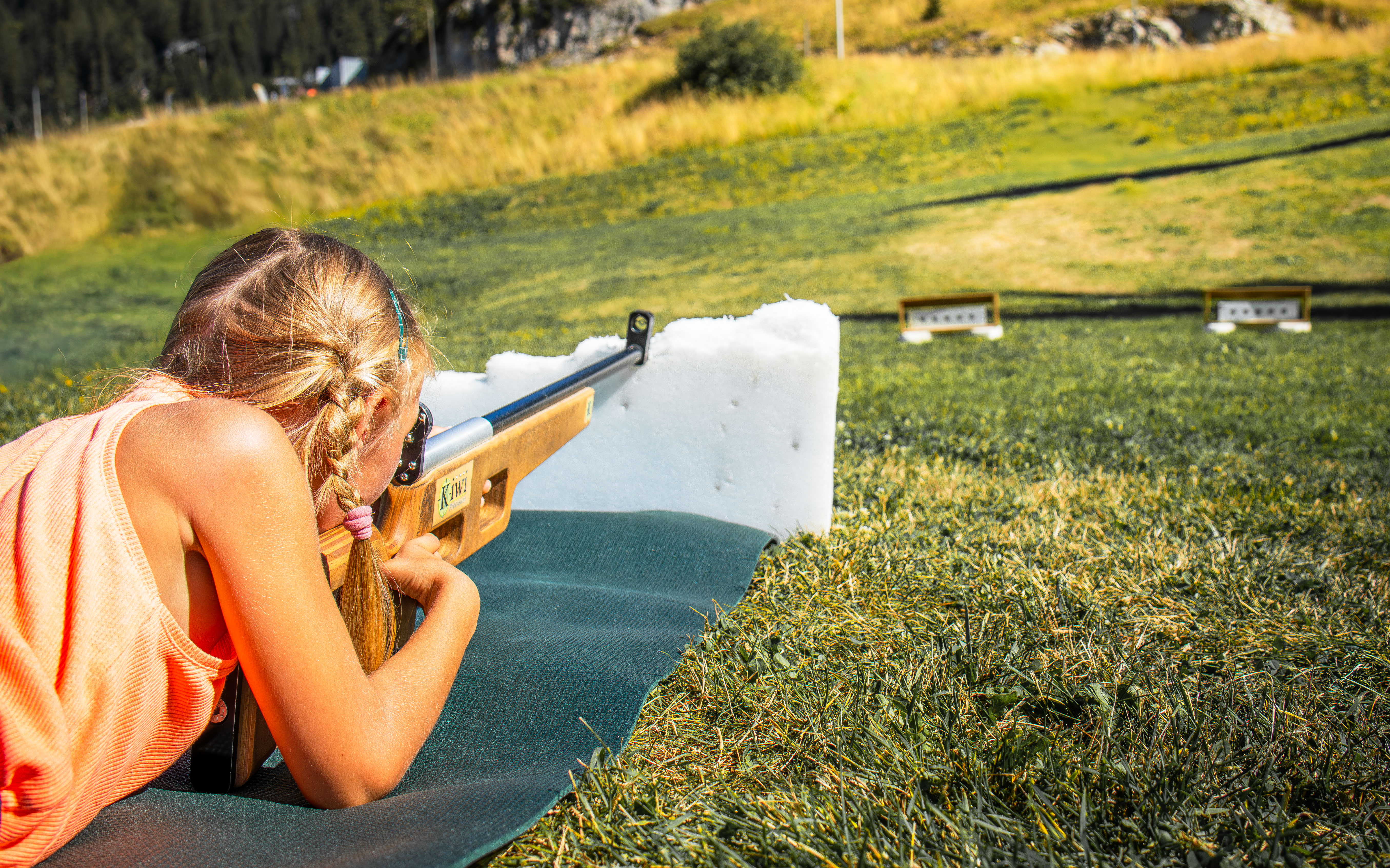 A little girl aims a laser rifle at targets in front of her