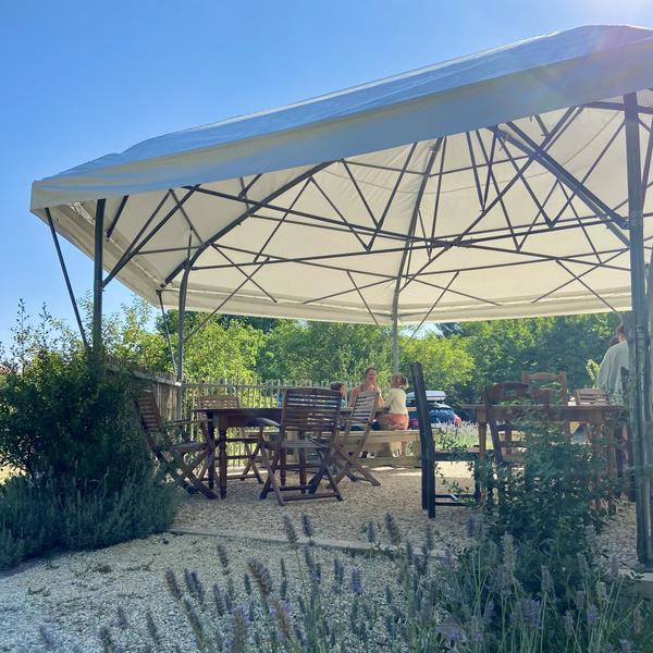 Un grand tivoli avec des tables et des chaises en bois.