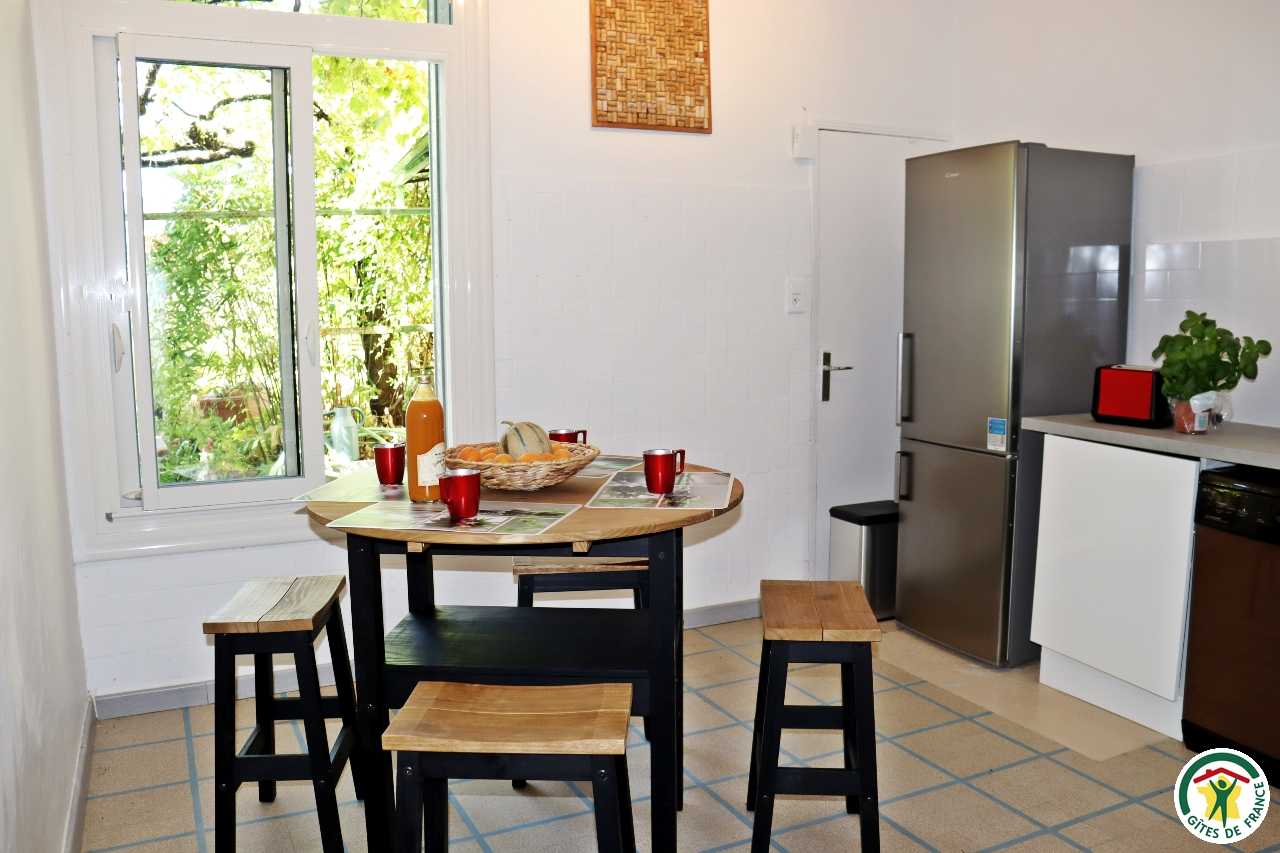 Cuisine équipée avec table haute et tabourets