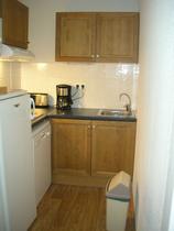 Coin cuisine avec ameublement bois, parquet au sol