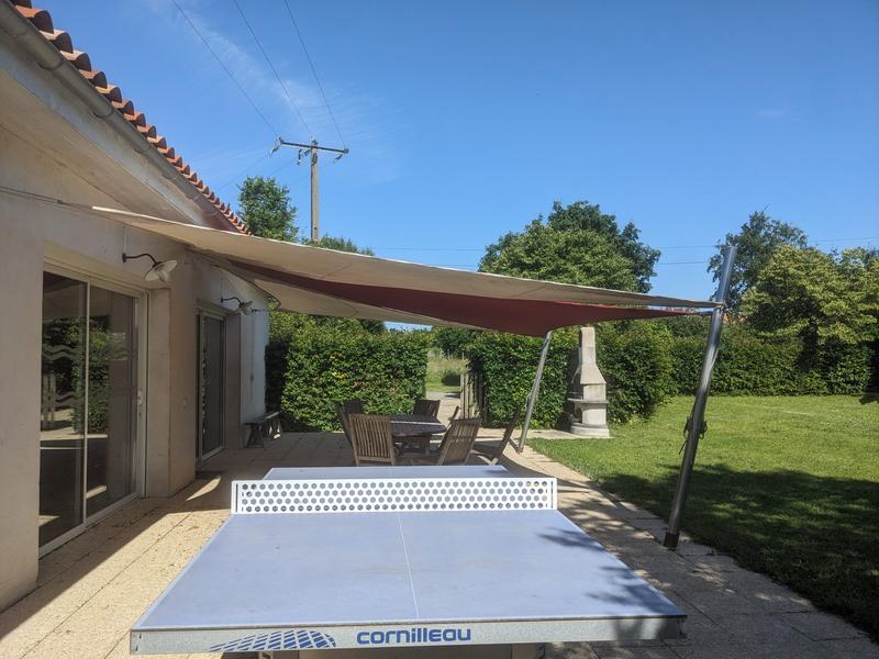 Terrasse abritée avec tablede ping-pong, salon de jardin et barbecue