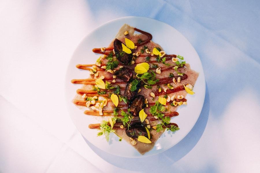 Une assiette estivale avec des figues, des herbes aromatiques, des fleurs