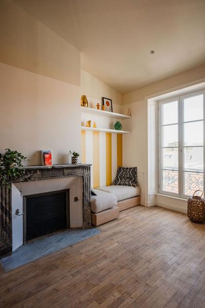 Un coin repos dans un dortoir, avec une cheminée de des banquettes.