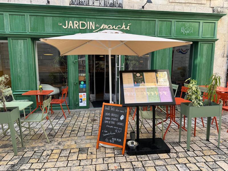La terrasse extérieur côté rue, avec des tables et des parasols.