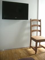 Coin séjour avec TV, parquet au sol