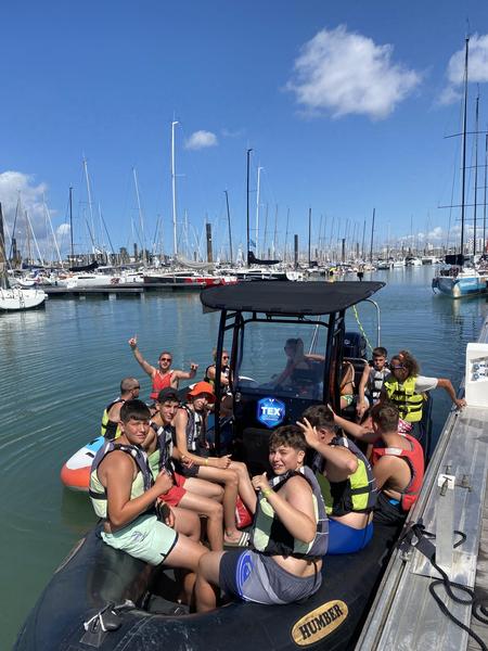 une quinzaine de joueurs sur un bateau et un paddle géant, amaré dans le port.