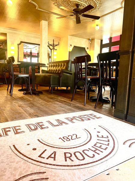 L'entrée du café, avec l'inscription "Café de la Poste -1922 - La Rochelle" au sol.