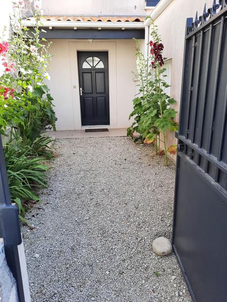 L'entrée côté rue, avec gravillons, portail et porte d'entrée.