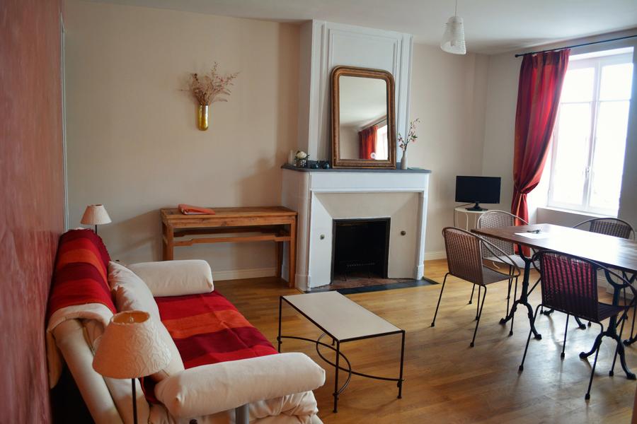 Salle de séjour avec canapé, cheminée, table et chaises