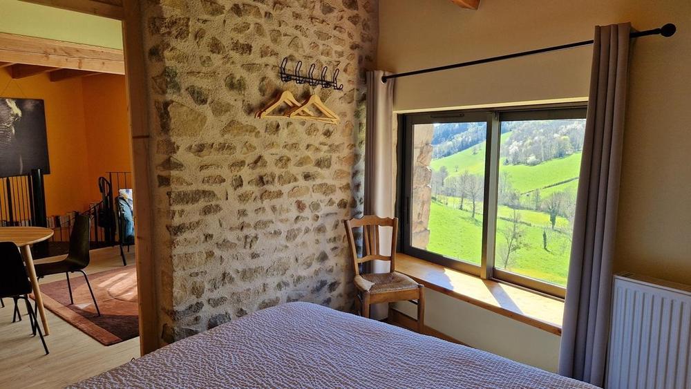 Gîte - 4 personnes - au Grand Peisselay à VALSONNE en Haut Beaujolais : la chambre disposant d\'un lit pour 2 personnes au même niveau que le séjour et la salle d\'eau avec toilettes.