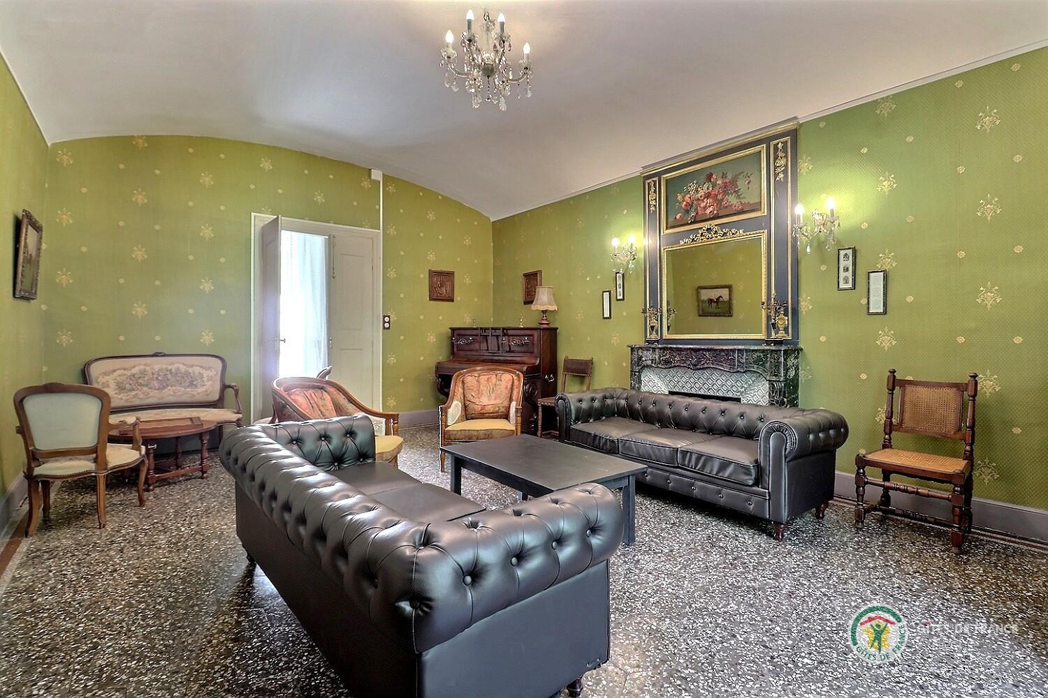 Salon avec deux canapés, TV écran plat et piano