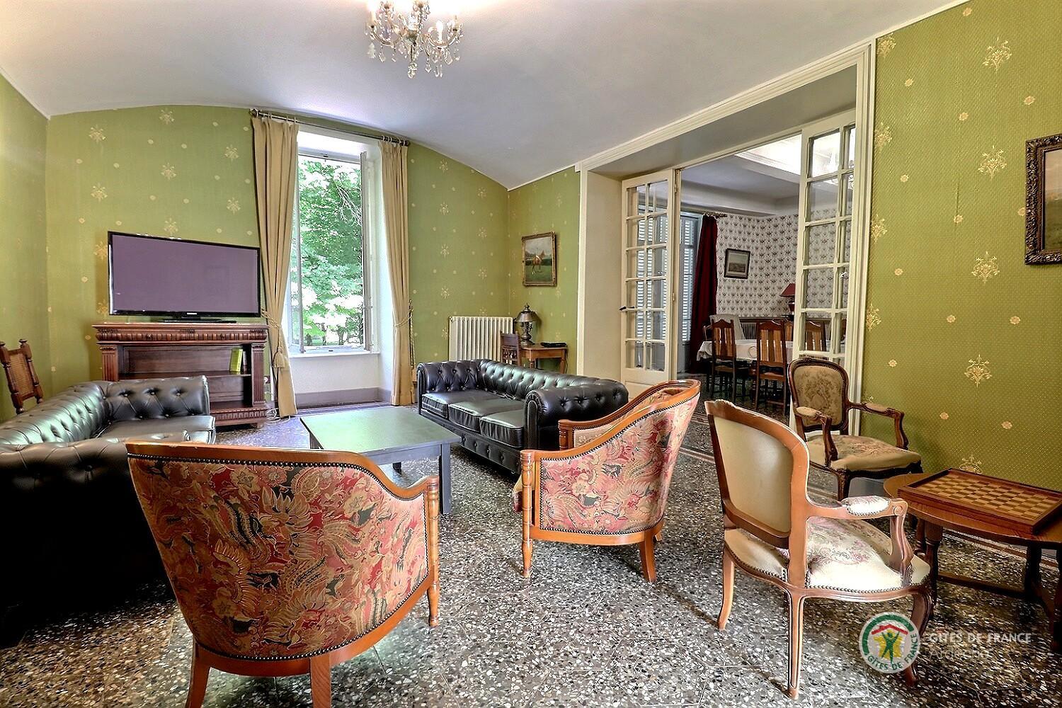 Salon avec deux canapés, TV écran plat et piano